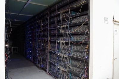 A mining farm filled with rows of mining rigs, showcasing the scale and infrastructure required for successful cryptocurrency mining.